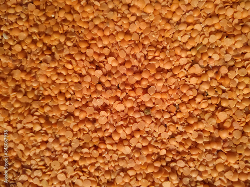 Red raw organic lentils texture. Food ingredient background. Natural