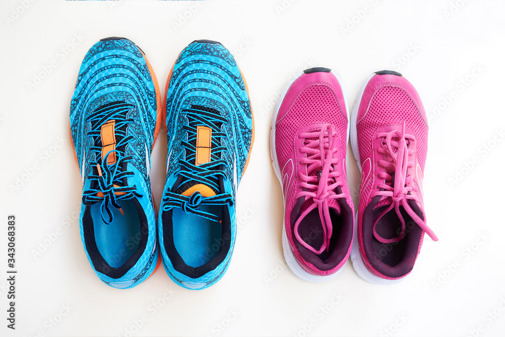Pair of men's blue sneakers and pair of women's pink sneakers on white background. Pair of men's blue sneakers and pair of women's pink sneakers on white background.