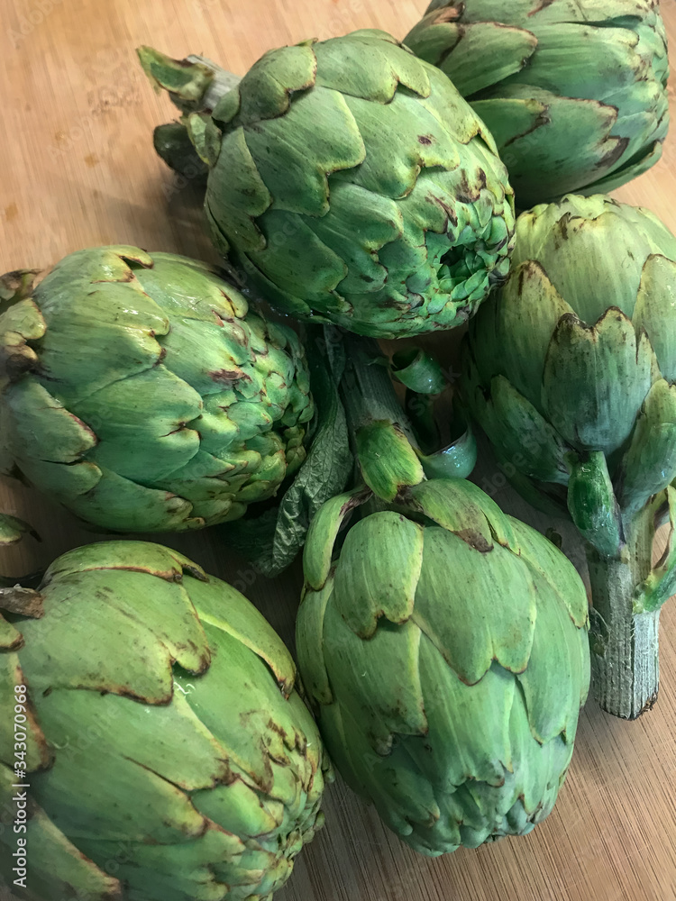 Obraz premium Raw artichokes on wooden table