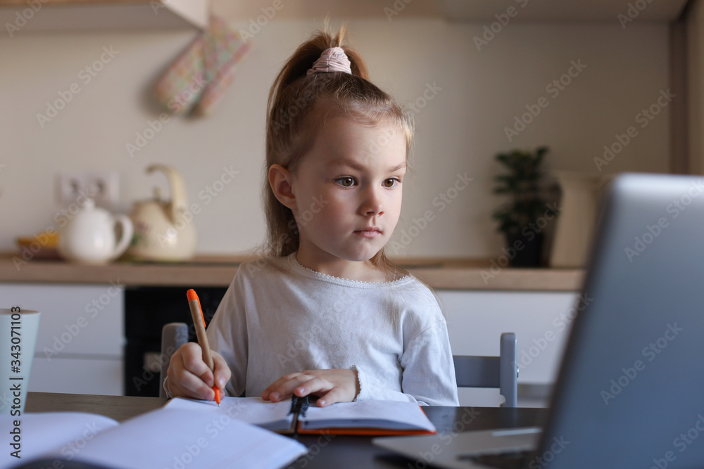 Serious little girl handwrite study online using laptop at home, cute happy small child take Internet web lesson or class on PC. Serious little girl handwrite study online using laptop at home, cute happy small child take Internet web lesson or class on PC.