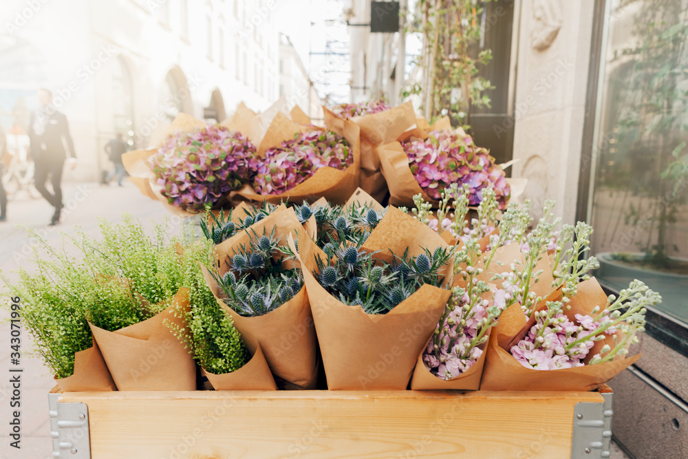 Lot of flowers in the wooden box at the street near flower shop. Selective focus Lot of flowers in the wooden box at the street near flower shop. Selective focus