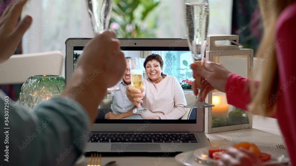 A young couple and an elderly couple celebrate together Using Laptop Video Call. Social distancing, self isolation during quarantine