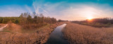 Spring rural landscape in the evening. Aerial view. Panoramic view of the narrow river during sunset. Panorama 180 from 21 images