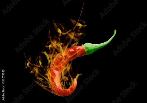 Red hot chili pepper with burning flames isolated on black background