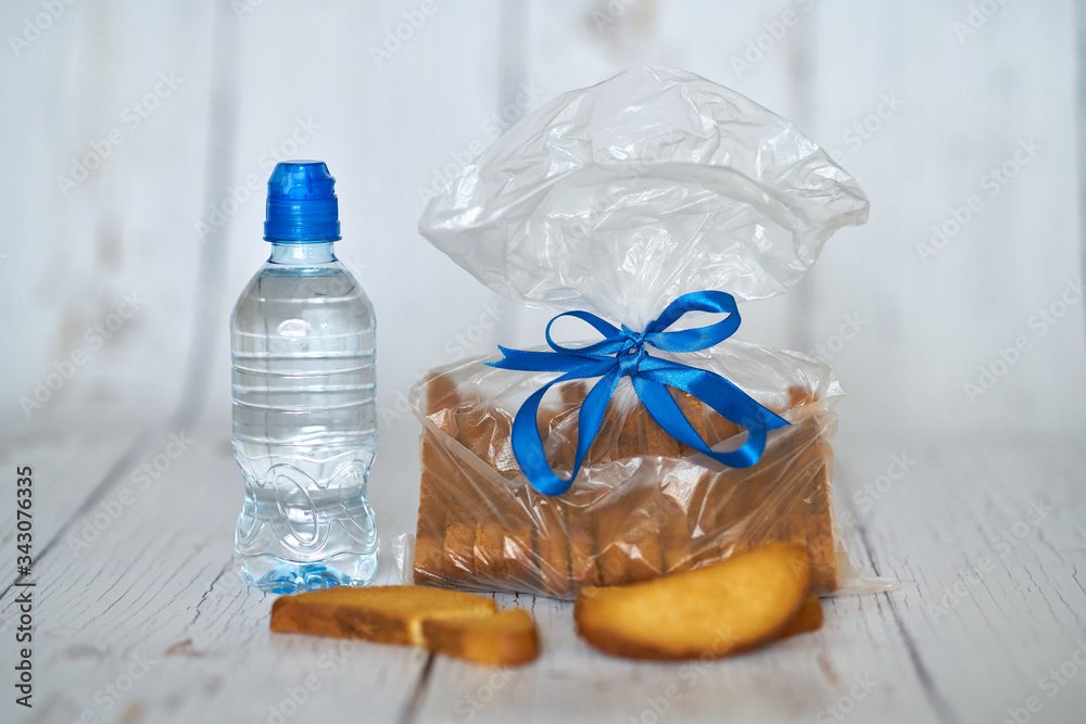 A bottle of water, crackers, drying on the background of boards for a healthy lifestyle. A bottle of water, crackers, drying on the background of boards for a healthy lifestyle.