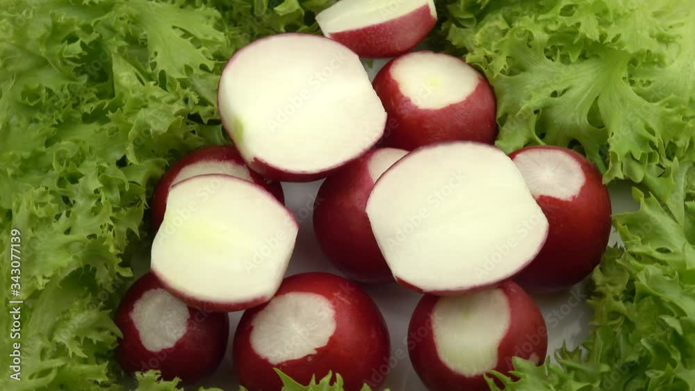 Whole radish and its' slices lay on the lettuce leaves Whole radish and its' slices lay on the lettuce leaves