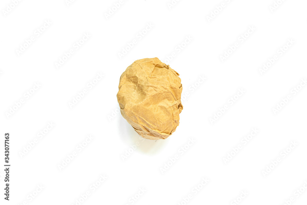 A crumpled ball of yellow craft paper on a white background and a shadow. A crumpled ball of yellow craft paper on a white background and a shadow.