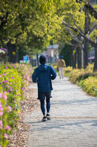 朝の公園でジョギングしている男性 © zheng qiang