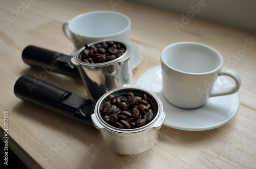Filter holder and coffee beans with white coffee cup.