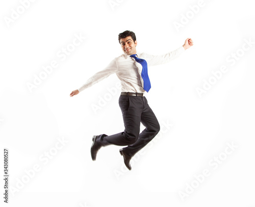Young office corporate man jumping high spreading his arms with joy wearing blue tie isolated on a white background