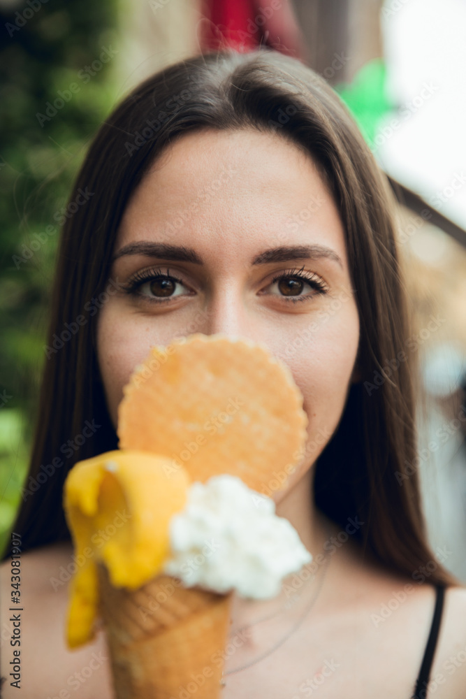 Portrait of brunette girl with lemon and vanilla ice cream in summer in Milan city, Italy