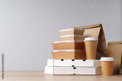 Many various take-out food containers  pizza box  coffee cups and paper bags on light grey background. Food delivery