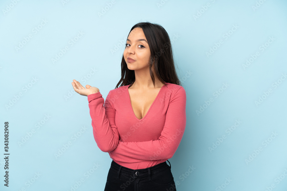 Young mixed race woman isolated on blue background unhappy for not understand something Young mixed race woman isolated on blue background unhappy for not understand something