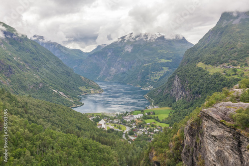 View to Geiranger fjord and eagle road surrounded by clouds from Dalsnibba mountain, serpentine road, Norway, selective focus. Village in Flam - Norway - nature and travel background