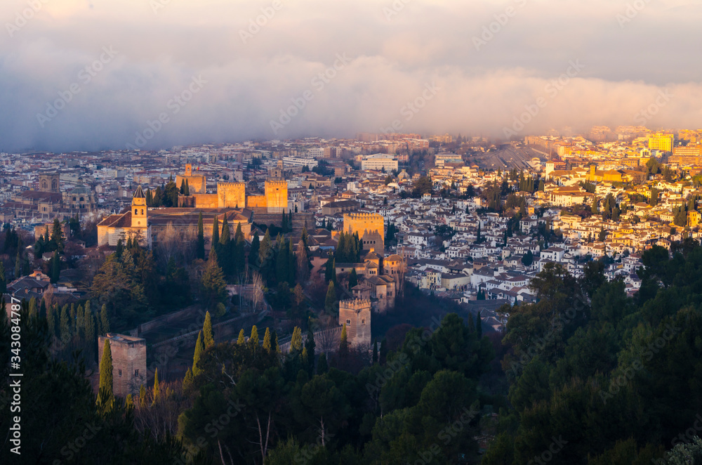 View of the Alhambra and the Generalife and the city of Granada from the viewpoint of the Silla del Moro at sunrise.