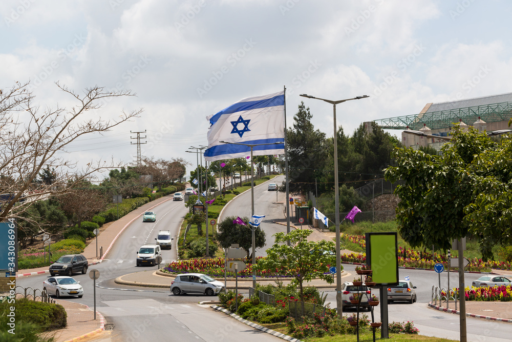 Fototapeta premium White and blue ribbons on sky background. Flags and decorations for the independence day in city Nof HaGalil.