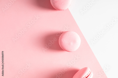 Pink macaroons on pink and white background. Almond cookies as  background. Sweet french macaroon. Flat lay, top view, copy space. Flat lay, top view, copy space