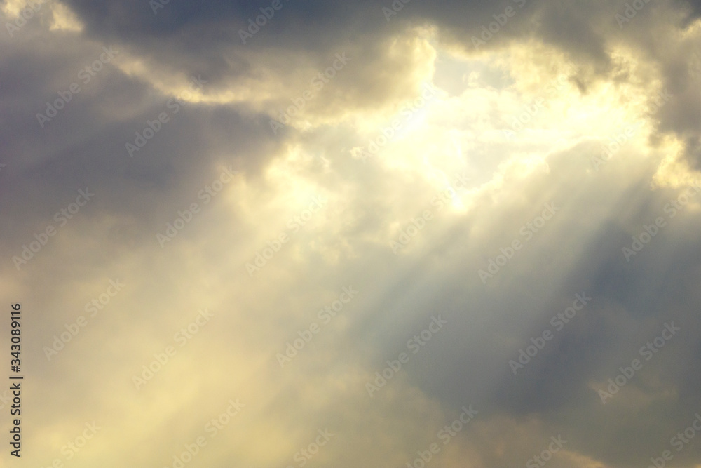 Natural sky. The rays of the sun in the middle between the dark clouds around. Beautiful background, wallpaper, texture