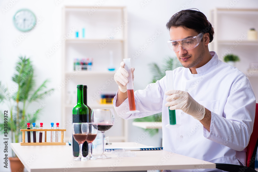 Male chemist examining wine samples at lab Male chemist examining wine samples at lab