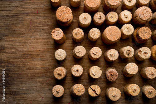 Wine corks of different sizes  standing upright on an old wooden surface. Background for liquor.