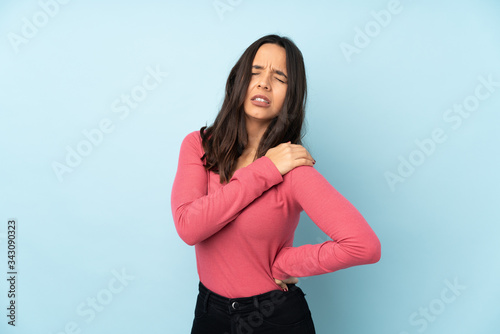 Young mixed race woman isolated on blue background suffering from pain in shoulder for having made an effort