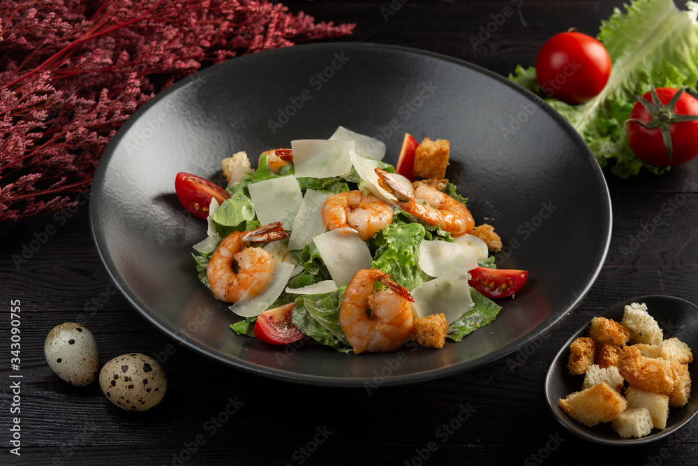 caesar salad with shrimp on a dark wooden background caesar salad with shrimp on a dark wooden background