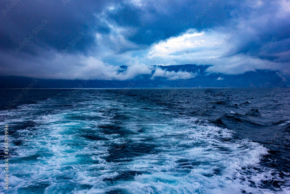Storm clouds and raging waves in the sea in the evening during a storm in winter.