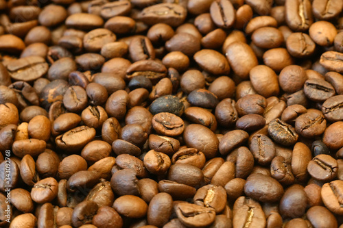 Brown roated coffee beans background, closeup photo