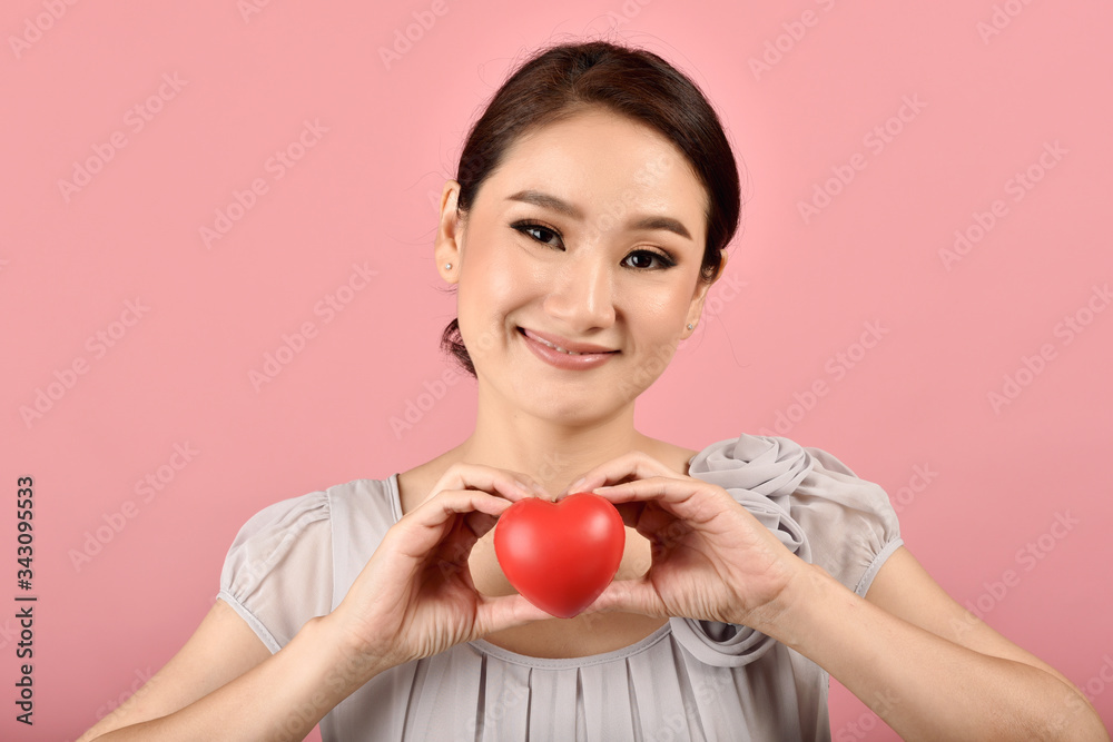 Gentle asian woman holding red heart, Happy smiling girl showing love sign to support and encourage, Cardiac health checkup. Gentle asian woman holding red heart, Happy smiling girl showing love sign to support and encourage, Cardiac health checkup.