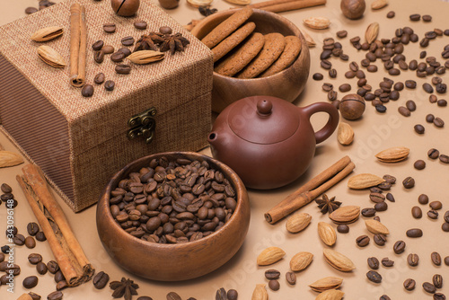 Coffee beans, teapot, oatmeal cookies, cinnamon, almond and macadamia. Top view gift set with spice