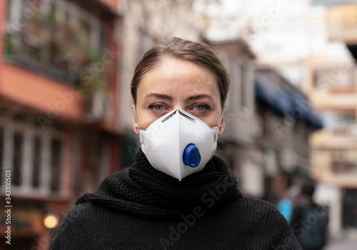 Portrait of young woman with colorful eyes having a facial mask