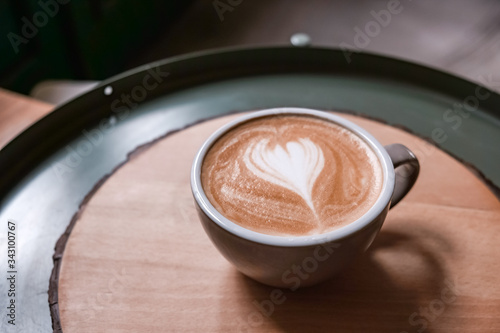 Three-quarter view of coffee latte on wooden circle table