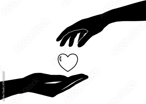 There’s a hand giving a heart to another one’s hand. Concept about love, care, sharing, donation, human kindness.