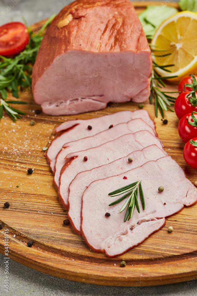 Sliced ham with spices, lettuce, avocado and tomatoes on wooden cutting board. Сold meat plate. Fresh prosciutto Sliced ham with spices, lettuce, avocado and tomatoes on wooden cutting board. Сold meat plate. Fresh prosciutto