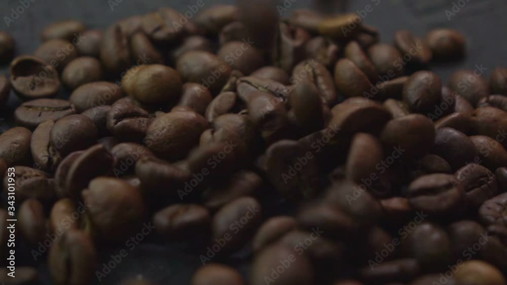 Coffee beans fall on a stone surface in slow motion Coffee beans fall on a stone surface in slow motion