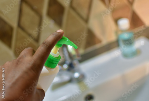 hand taking handwash liquid from bottle to wash hands and protect from corona virus covid-19