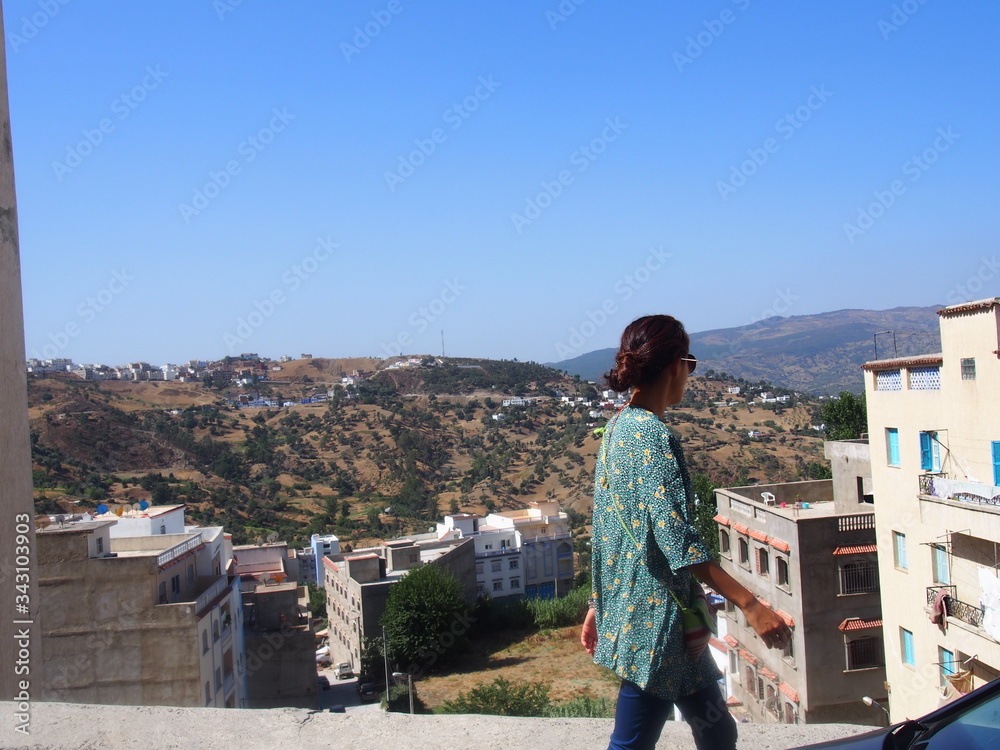 A woman walks outside the old town, Medina, Chaouen (Chefchaouen), Morocc A woman walks outside the old town, Medina, Chaouen (Chefchaouen), Morocc