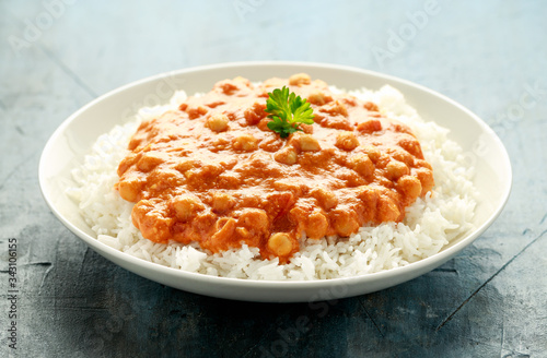 Spicy chickpeas curry with rice, tomato and Poppadoms in white plate. Healthy tasty vegetarian food