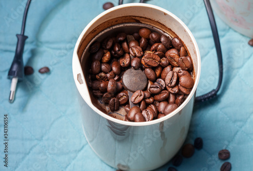 Macro photo of freshly ground coffee in electric coffee grinder.