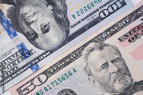 100 dollar bill and 50 dollar bill are side by side diagonal. 150 dollars money background.