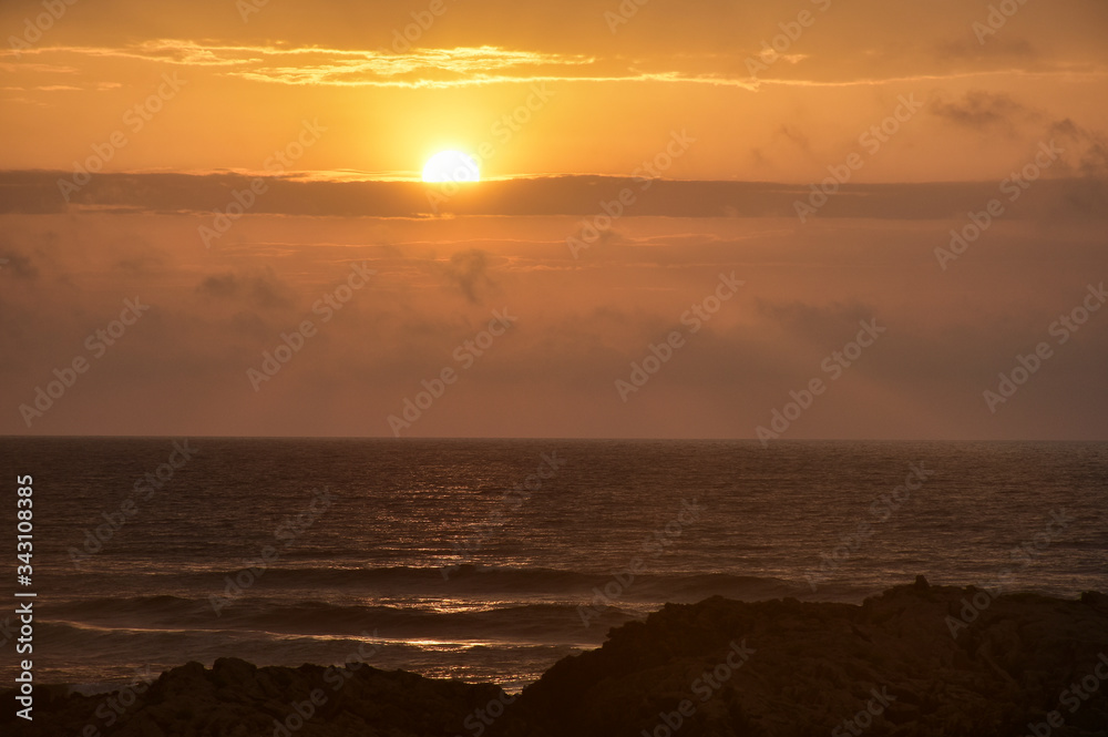 beautiful orange sunset over the sea and rocks