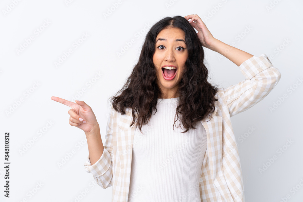 Mixed race woman over isolated white background surprised and pointing finger to the side Mixed race woman over isolated white background surprised and pointing finger to the side