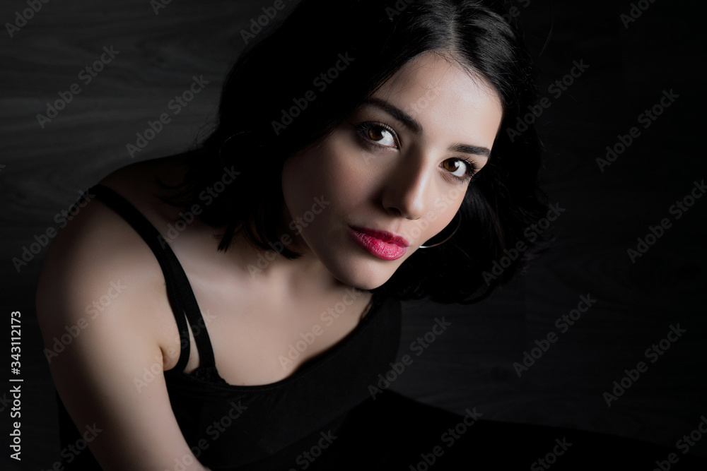 Naklejka premium Young woman looking at camera isolated on black background. Beautiful woman portrait.