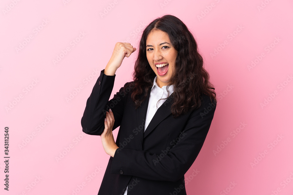 Mixed race business woman over isolated pink background making strong gesture Mixed race business woman over isolated pink background making strong gesture