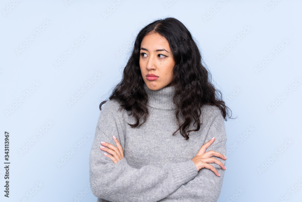 Spanish Chinese woman over isolated blue background portrait