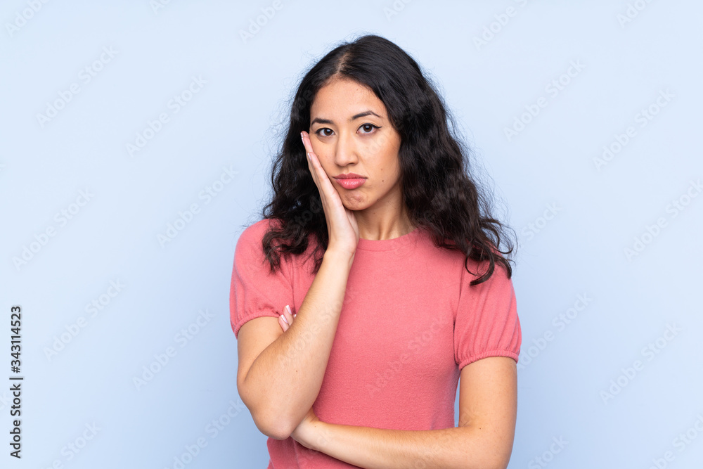 Mixed race woman wearing a sweater over isolated blue background unhappy and frustrated Mixed race woman wearing a sweater over isolated blue background unhappy and frustrated