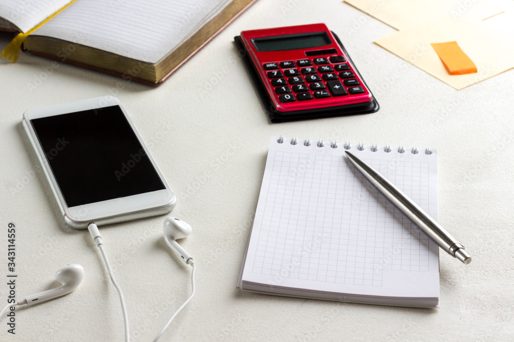Notebook and pen, selfphone and headphones, calculator. Work from home. Notebook and pen, selfphone and headphones, calculator. Work from home.