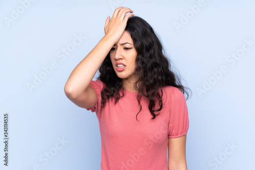 Mixed race woman wearing a sweater over isolated blue background having doubts with confuse face expression