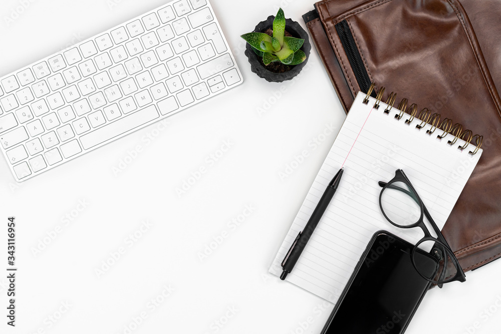 flat-lay of working or writing place. layout. computer keyboard, glasses, smartphone, notebook and laptop case. copy space layout