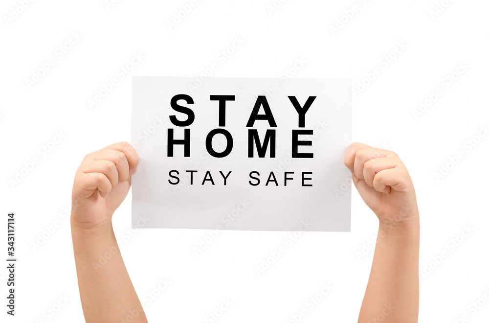 Kid's hands holding Stay home, stay safe message on paper isolated Kid's hands holding Stay home, stay safe message on paper isolated